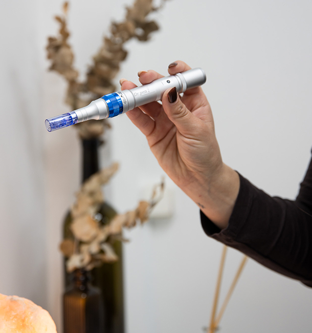 Especialista sujetando dispositivo Dermapen para tratamiento facial en Villena